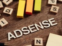 Googleアドセンス合格をテーマにした木製ブロックのイメージ。木の机の上に「ADSENSE」の文字とカラフルな棒が並び、ブログ審査対策を象徴している。