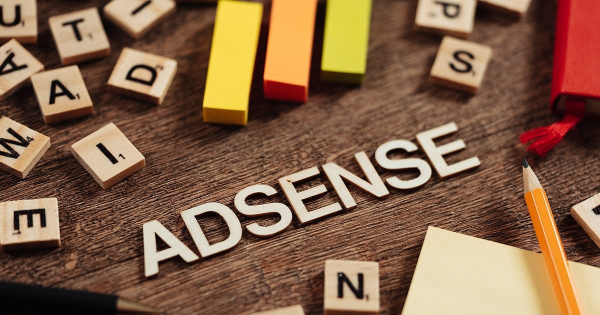 Googleアドセンス合格をテーマにした木製ブロックのイメージ。木の机の上に「ADSENSE」の文字とカラフルな棒が並び、ブログ審査対策を象徴している。