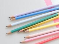 カラフルな鉛筆が並ぶデスクのイメージ。個人事業主・フリーランス向け事務用品・備品のおすすめ通販サイト紹介記事のアイキャッチ画像。