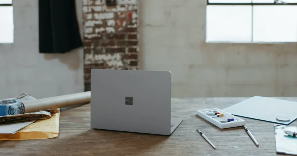 Microsoft 365が入ったノートパソコンと文具が並ぶ作業デスク