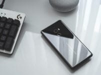 スマートフォンとキーボードが並ぶデスクのイメージ。やよいの青色申告オンラインのスマホアプリ性能検証記事のアイキャッチ画像。