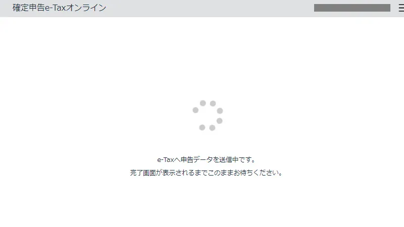 確定申告e-Taxオンラインの画面。申告データを送信中で、中央に読み込み中の表示と「e-Taxへ申告データを送信中です。完了画面が表示されるまでこのままお待ちください。」というメッセージが表示されている