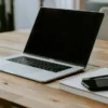 Microsoft365 ClassicからPersonalへの切り替えを検証するノートPCとノート、スマートフォンが置かれたデスク