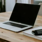 Microsoft365 ClassicからPersonalへの切り替えを検証するノートPCとノート、スマートフォンが置かれたデスク