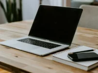 Microsoft365 ClassicからPersonalへの切り替えを検証するノートPCとノート、スマートフォンが置かれたデスク